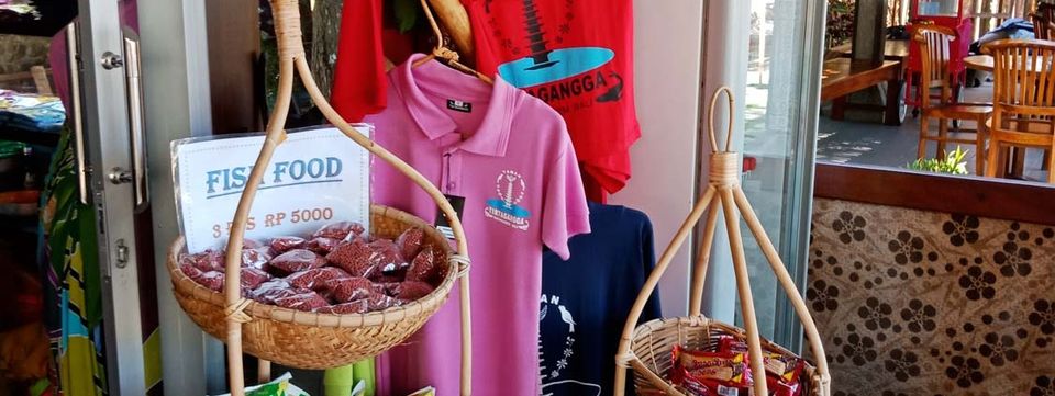 Toko suvenir Taman Tirtagangga dengan pakan ikan dan kaos